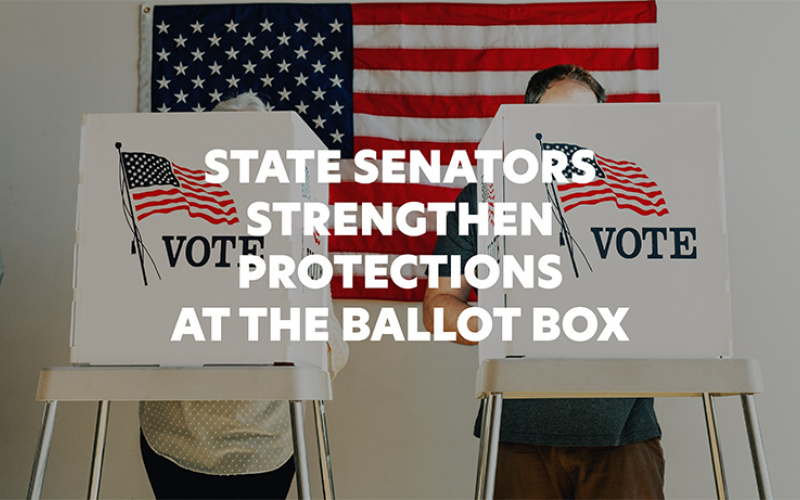 Two U.S. citizens behind a ballot box