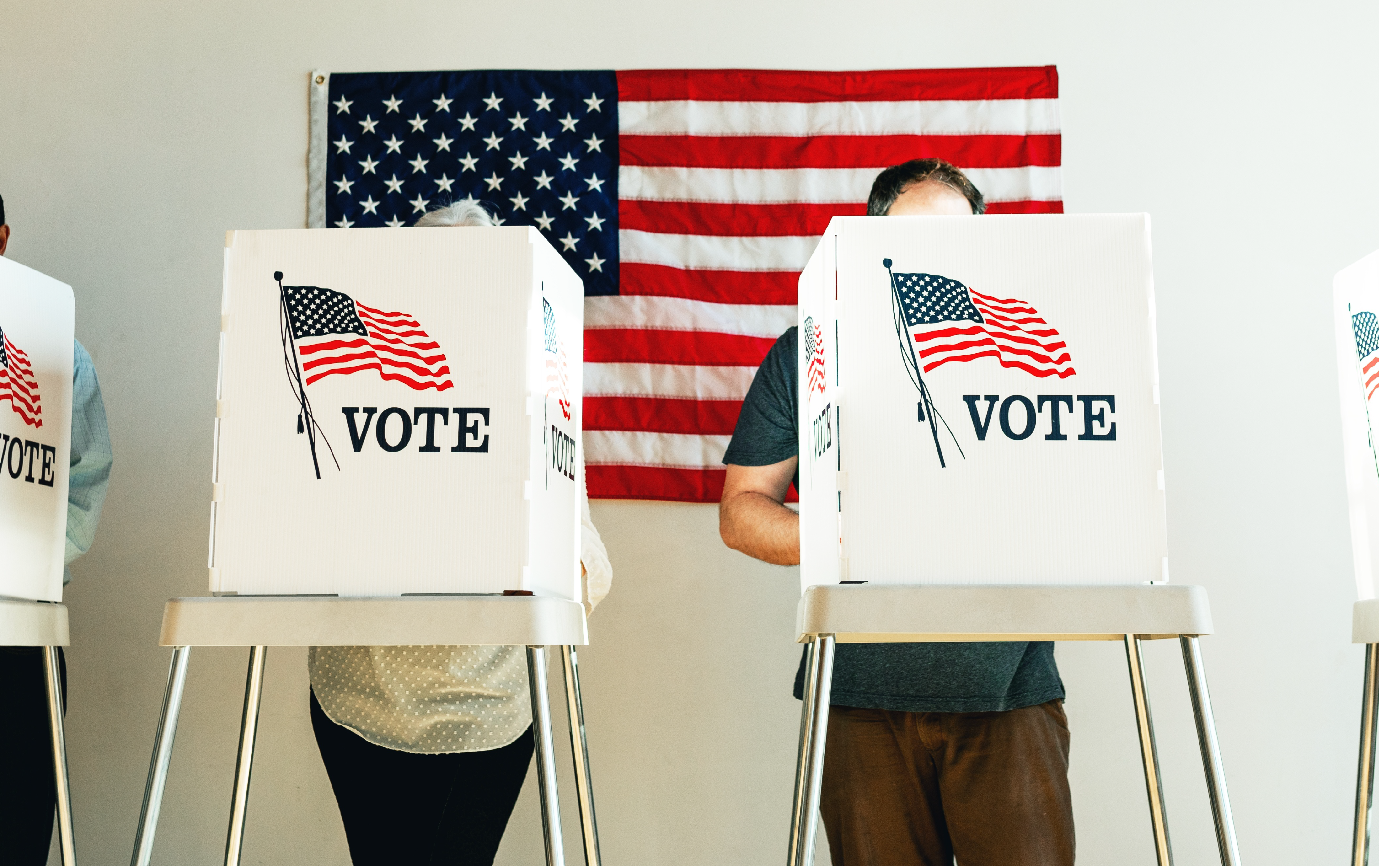 Two U.S. citizens behind a ballot box